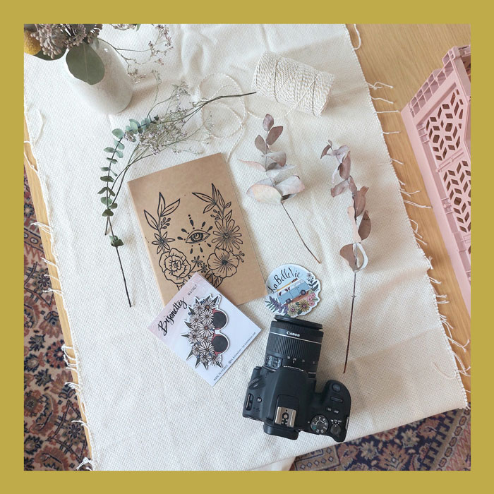 Notebook, magnet floral branches on tabletop with camera